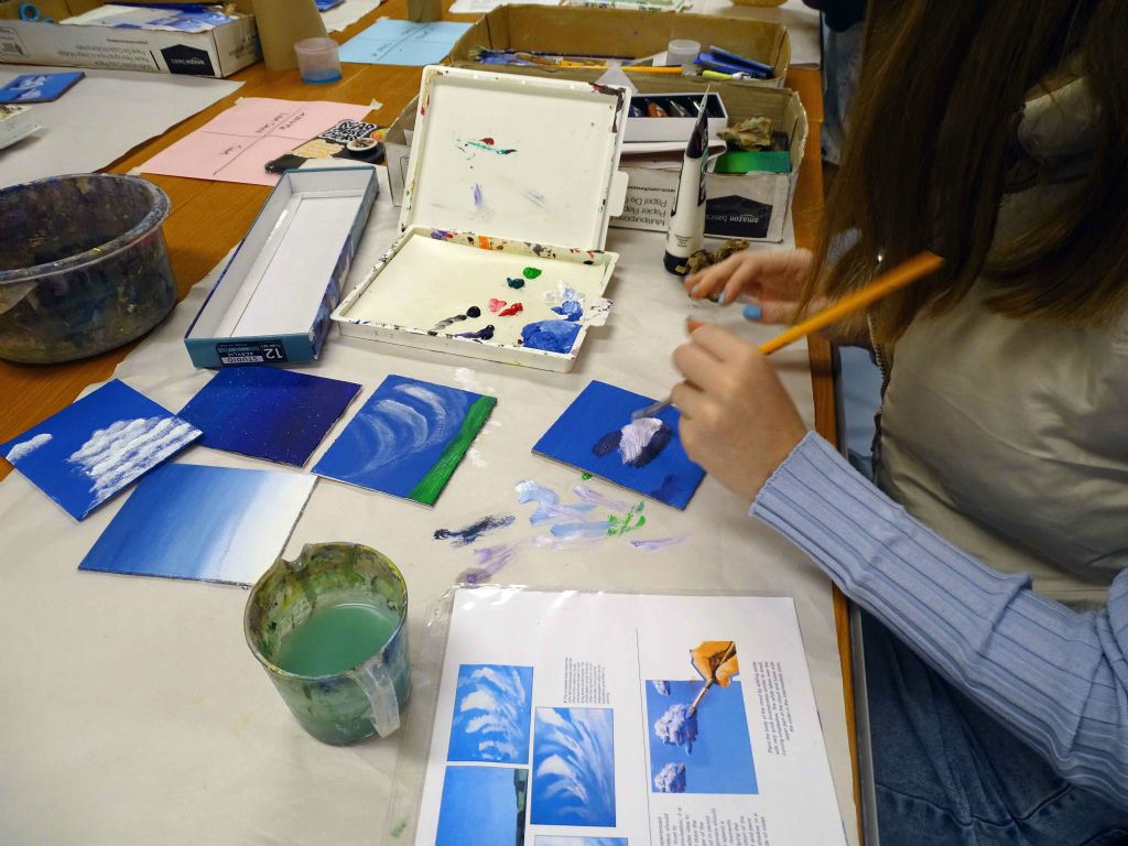 Painting I student practices painting clouds